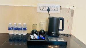 a coffeemaker sitting on a counter with bottles of water at The Ocean Crown in Udupi