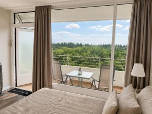 a bedroom with a bed and a balcony with a table at Timmendomizil - schöne Ferienwohnung in bester Lage - Sonnenseite in Timmendorfer Strand