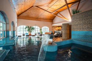 an indoor swimming pool with water in a house at Bodrogi Kúria Wellness Hotel in Inárcs