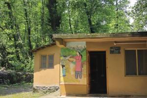 a painting on the side of a building with a man holding a bowl at NotOnMap- Saal River Homestay in Chamba