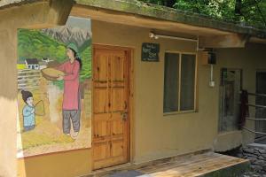 a mural on the side of a building with a person holding a bread at NotOnMap- Saal River Homestay in Chamba