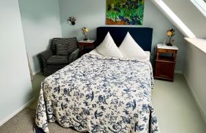 a bedroom with a bed with a blue and white comforter at Herzog Friedlich Hotel Garni in Friedrichstadt