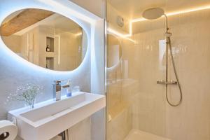 ein Badezimmer mit Dusche, Waschbecken und Spiegel in der Unterkunft C'Châtelet in Chartres