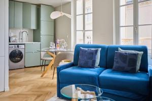 ein Wohnzimmer mit einem blauen Sofa und einem Tisch in der Unterkunft C'Châtelet in Chartres