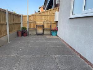 a patio with potted plants and a fence at Stylish Apartment Coppcliffe Grantham in Grantham