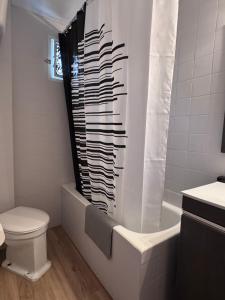 a bathroom with a toilet and a shower curtain at Casa en Manuel in Manuel