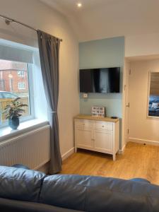 a living room with a couch and a flat screen tv at Stylish Apartment Coppcliffe Grantham in Grantham