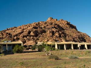 a building with a mountain of rocks behind it at Namib Naukluft Lodge in Solitaire +44 photos