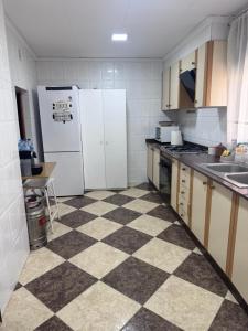 a kitchen with white appliances and a checkered floor at Casa en Manuel in Manuel