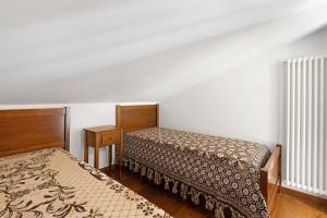 a bedroom with two beds and a table and radiator at La Mansarda di Cecè in Ostuni
