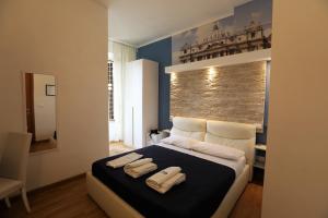 a bedroom with a bed with two towels on it at Rooma Beb in Rome