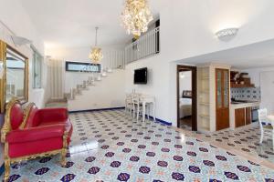 a living room with a red chair and a staircase at La Mansarda di Cecè in Ostuni