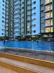 a swimming pool in front of some apartment buildings at Lois Ann Condo in Pontud