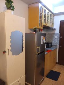 a kitchen with a stainless steel refrigerator and wooden cabinets at Lois Ann Condo in Pontud