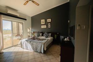 a bedroom with a bed and a sliding glass door at Namib Naukluft Lodge in Solitaire