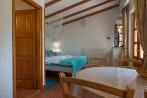 una camera da letto con un letto, un tavolo e delle sedie di Roberto Apartments a Veli Lošinj (Lussingrande)