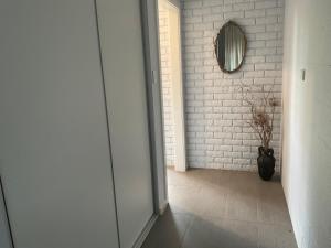 a hallway with a white brick wall and a mirror at Bruny Sunset Beach in Alonnah