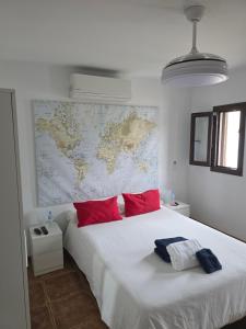 a white bed with red pillows and a map on the wall at Refugio Costa Teguise - Lanzarote in Costa Teguise