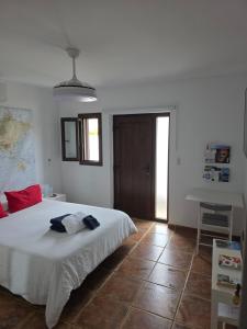 a bedroom with a white bed and a table and a door at Refugio Costa Teguise - Lanzarote in Costa Teguise