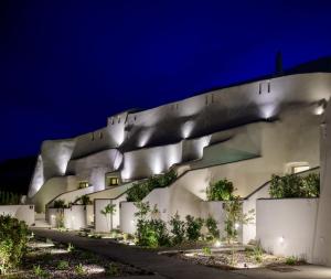 a building with lights on the side at night at Avelora Suites in Pyrgos +118 photos