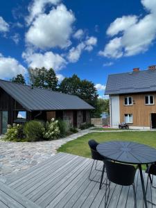 a patio with a table and chairs on a deck at Slow Home in Dziemiany