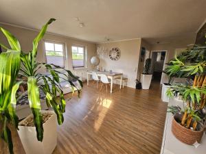 a living room with lots of plants and a table at Lake FeWo Santorini in Oberteuringen