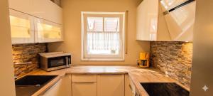 a kitchen with a sink and a microwave at Lake FeWo Santorini in Oberteuringen