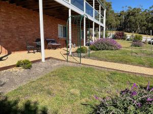 a house with a patio and a yard with flowers at Bruny Sunset Beach in Alonnah