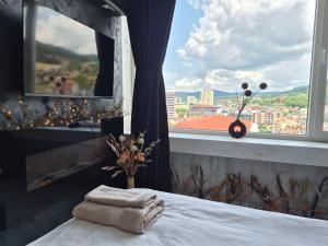 a bedroom with a bed and a window with a view at Balkan tower REST 2 Безплатно паркомясто in Gabrovo