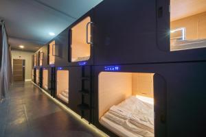 a row of bunk beds in a room at Urban Pod Capsule Hostel in Bangkok +17 photos