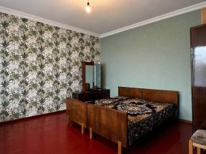 a bedroom with a bed in a room with a wallpaper at roomes in Surami