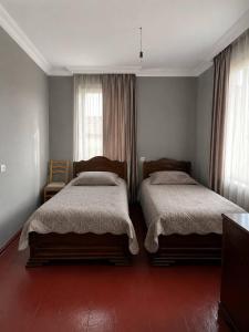 a bedroom with two beds and a window at roomes in Surami