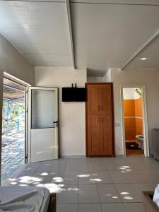 a room with a bed and a door and a bathroom at Blue Marli Rooms in Himare