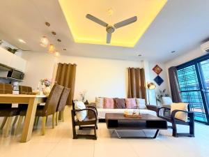 a living room with a ceiling fan and a table at Koh Sirey Beachfront Pool Villa in Phuket