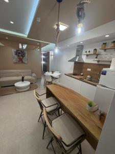 a kitchen and living room with a table and chairs at Lux In A Box, Apartments In the center in Nea Kallikrateia +88 photos