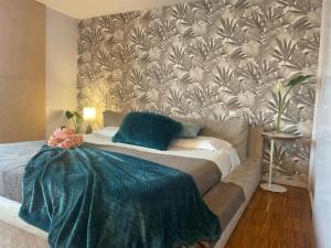 a bedroom with a bed with a green blanket on it at Gloria's Design House in Santiago de Compostela