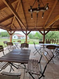 a wooden picnic table and chairs under a pavilion at Domki Strumieniowa in Wólka Tanewska