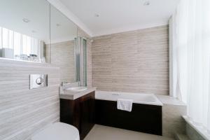 a bathroom with a tub and a sink and a toilet at The County Hotel Newcastle in Newcastle upon Tyne +54 photos