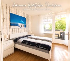 a bedroom with a bed and a window at Lake FeWo Santorini in Oberteuringen +1 photo