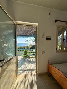 a bedroom with a view of the ocean through a sliding glass door at Blue Marli Rooms in Himare