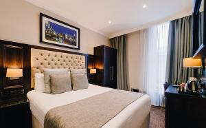 a hotel room with a bed and a large window at The County Hotel Newcastle in Newcastle upon Tyne