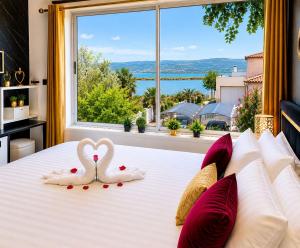 two white swans are sitting on a bed with a window at Luxury Beach Room in Frontignan