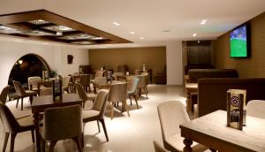 a restaurant with tables and chairs and a flat screen tv at Hotel A44 in Tétouan