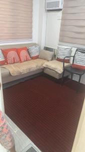 a small room with a couch and a red rug at Casa Rufina in Taluc