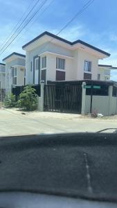 a house with a black gate in front of a street at Casa Rufina in Taluc