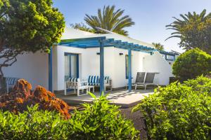 a small white house with a blue roof at Elba Premium Suites - Adults Only in Playa Blanca +24 photos