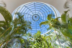 a glass ceiling with palm trees in a building at Elba Premium Suites - Adults Only in Playa Blanca