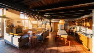 a living room with couches and a table and a kitchen at Chalet Drevarska in Benecko