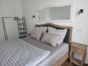a bedroom with a bed with a mirror on the wall at Apartmán Square Lipno in Horní Planá