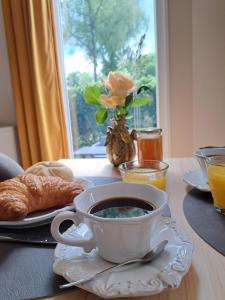 a table with a cup of coffee and a plate of croissants at De Huisbij in Oude Willem